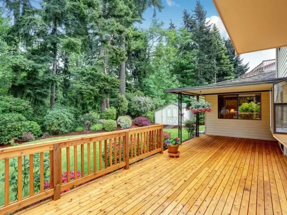 Wooden walkout deck. Well kept garden with bushes and flowers. Northwest, USA